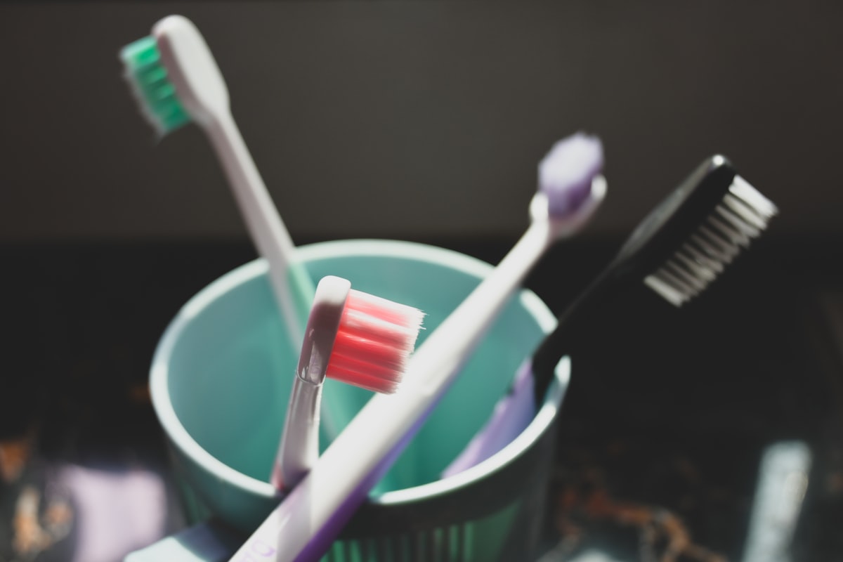 Deux brosses à dents dans un verre avec du dentifrice