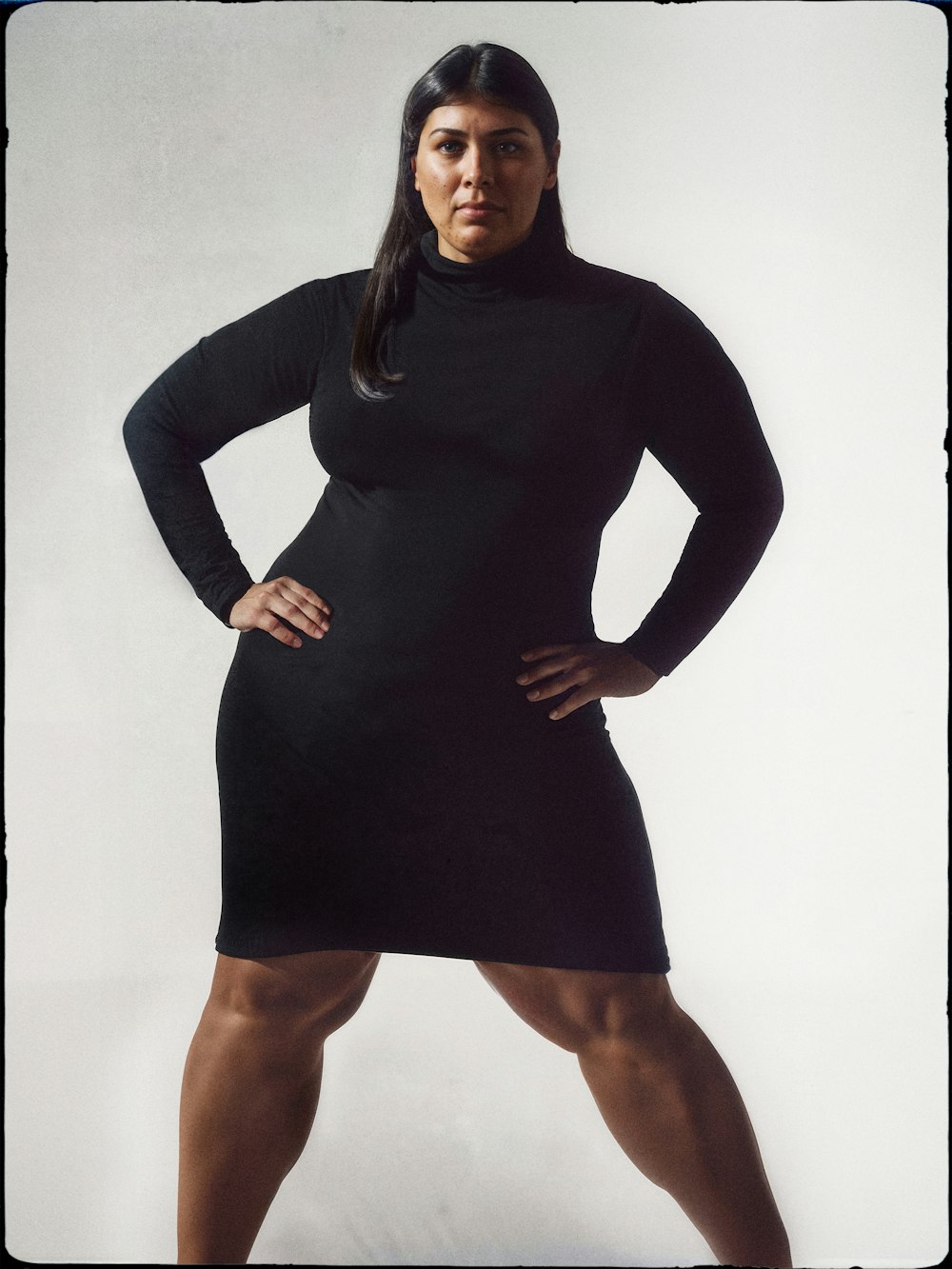 Imagen generada por Ai de una modelo de cabello oscuro con vestido negro con las manos en las caderas