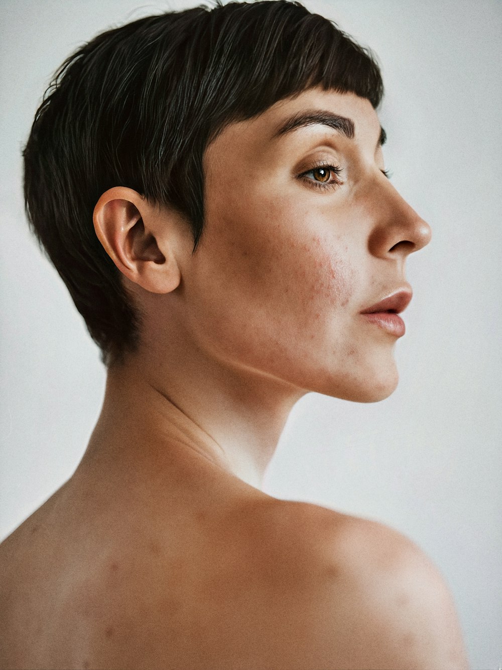 Portrait généré par l’IA d’un modèle aux cheveux noirs courts et aux épaules nues