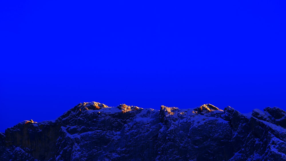 a plane flying over a mountain covered in snow