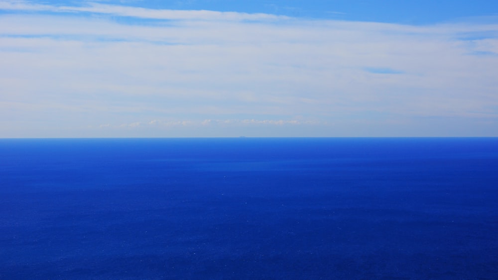 a plane flying over the ocean on a clear day