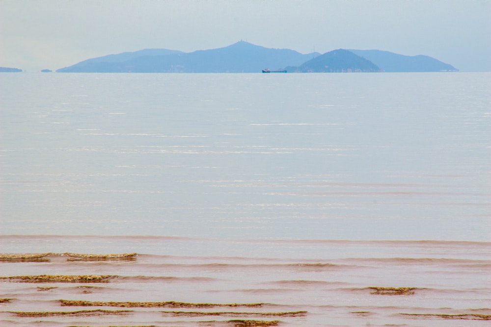 a large body of water with mountains in the background