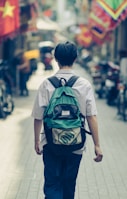 a man with a backpack walking down a street