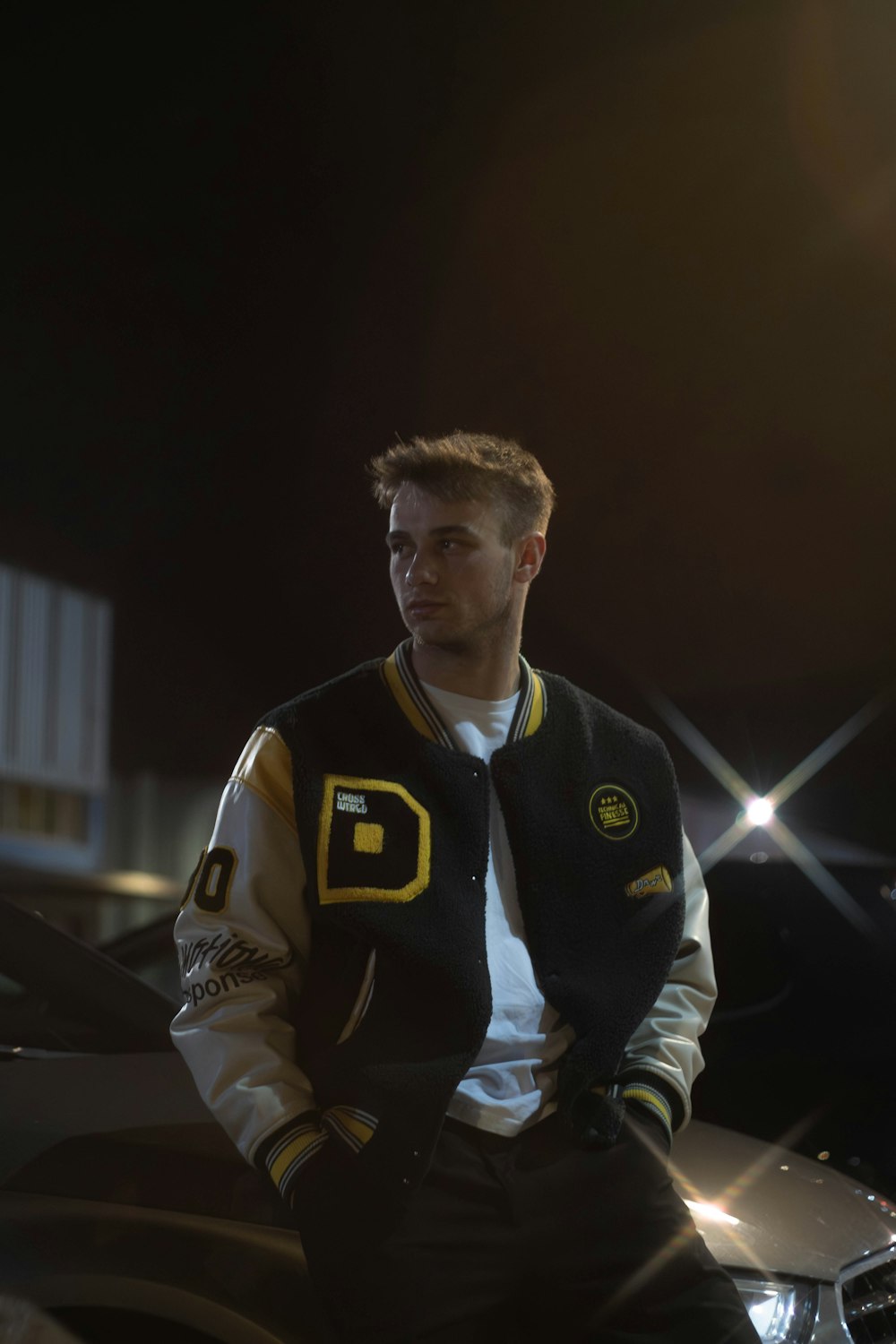 a man sitting on top of a car in a parking lot