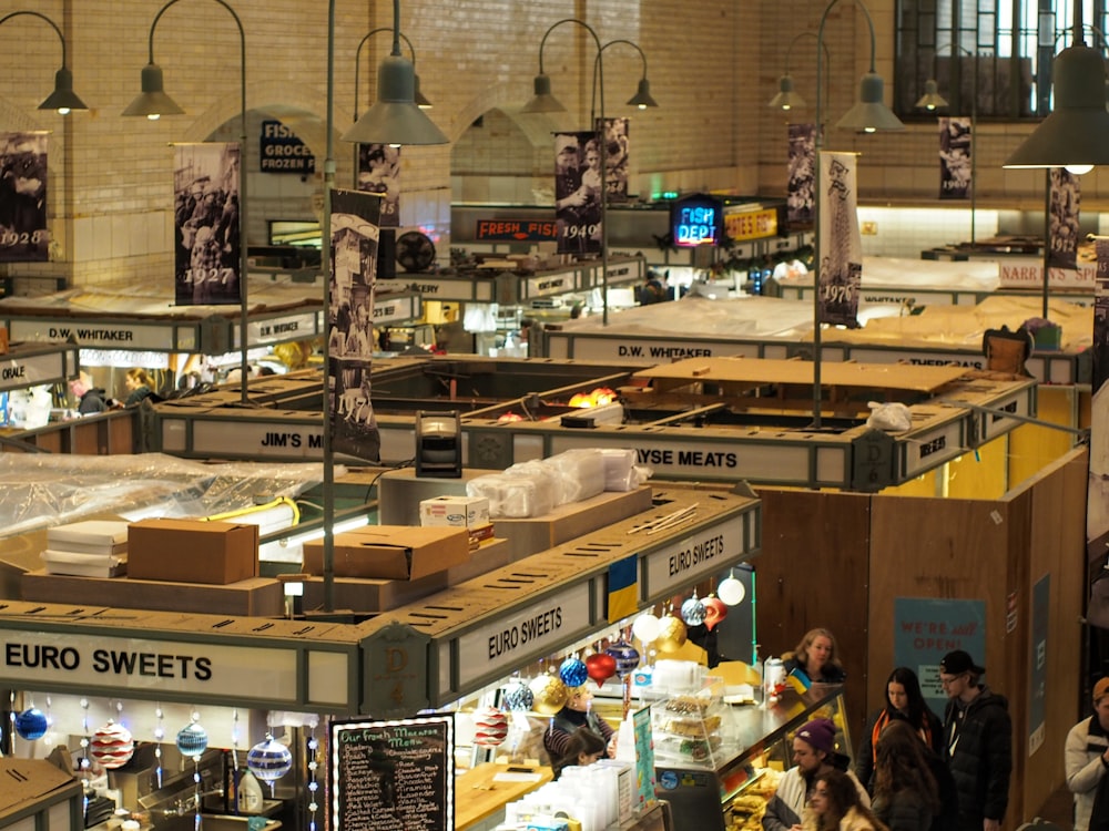 Un grupo de personas de pie alrededor de un mercado de alimentos