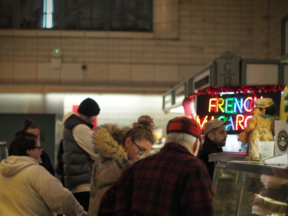 a group of people standing around a food stand