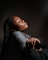 a woman with her eyes closed in a dark room