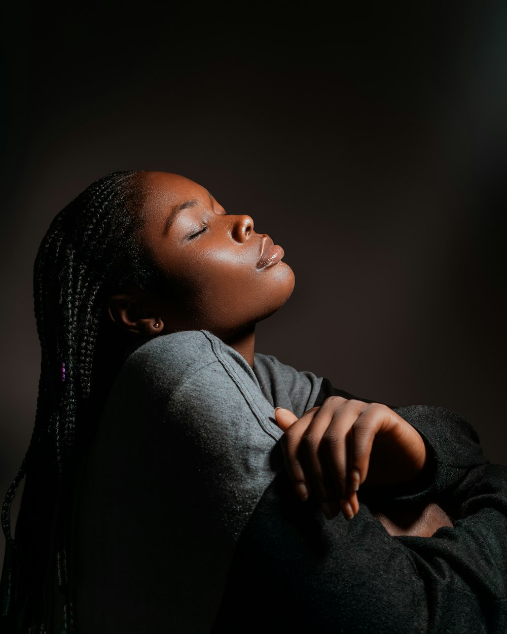 a woman with her eyes closed in a dark room