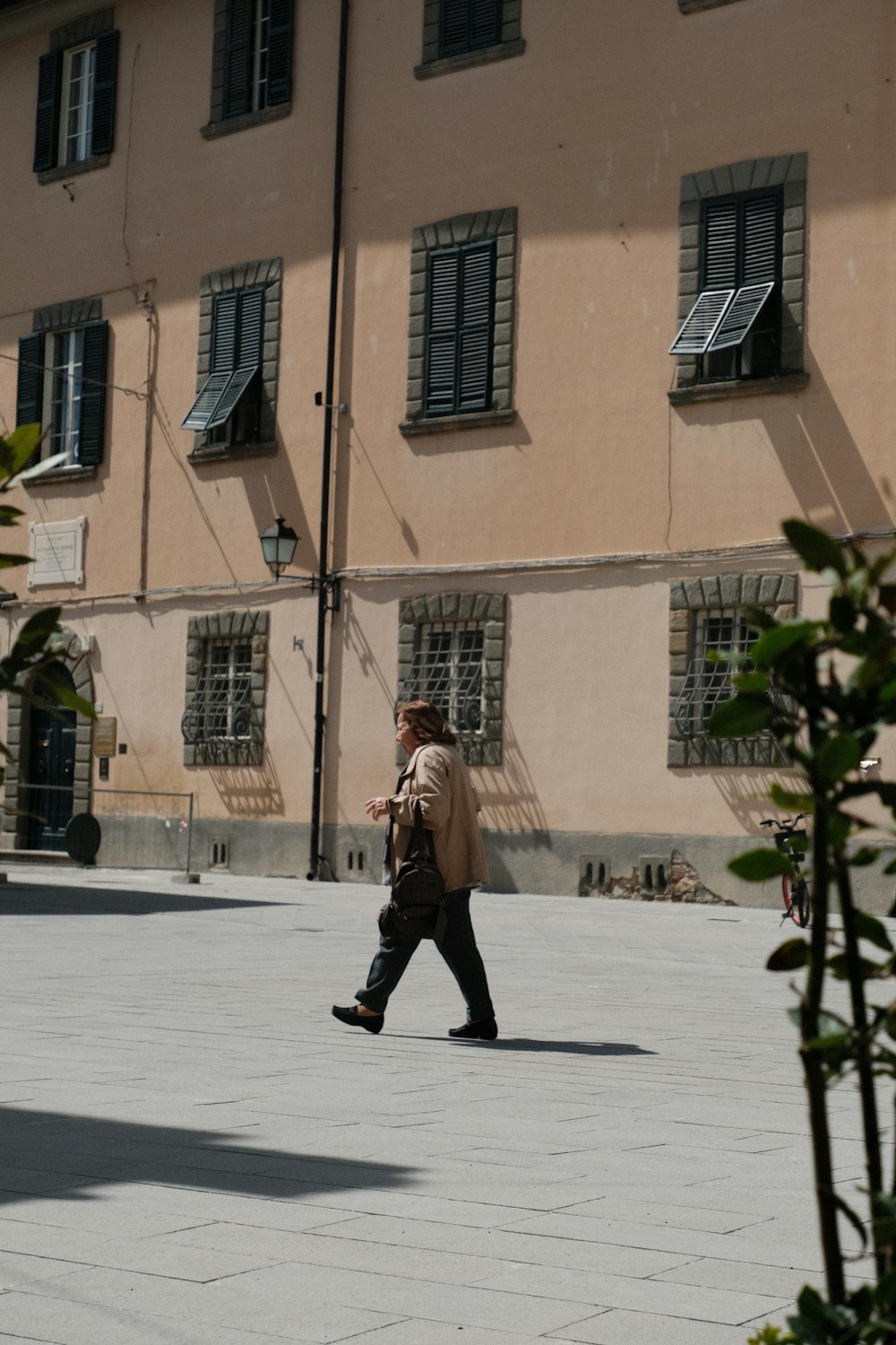 Un homme marchant dans une rue devant un grand immeuble