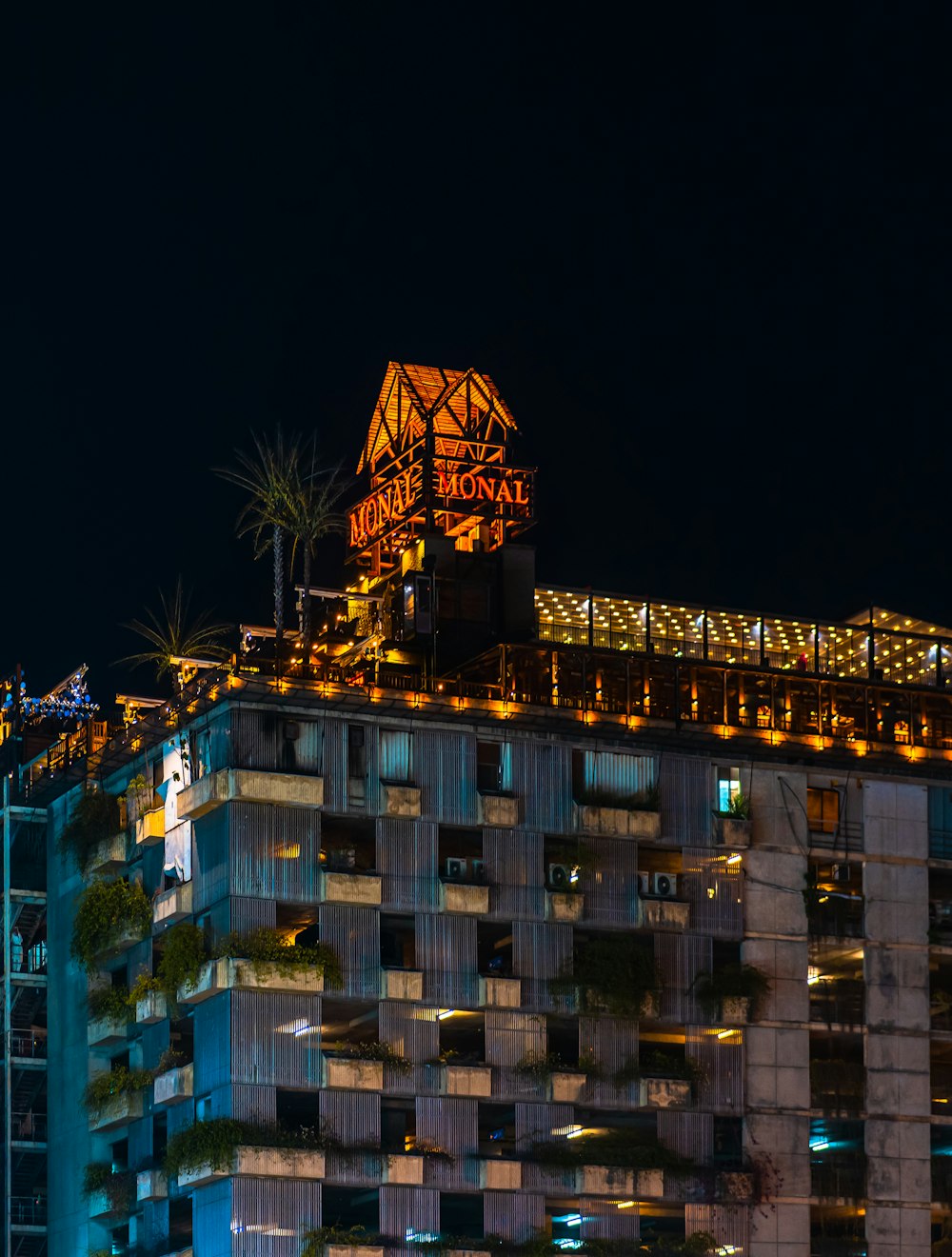 a tall building with a neon sign on top of it