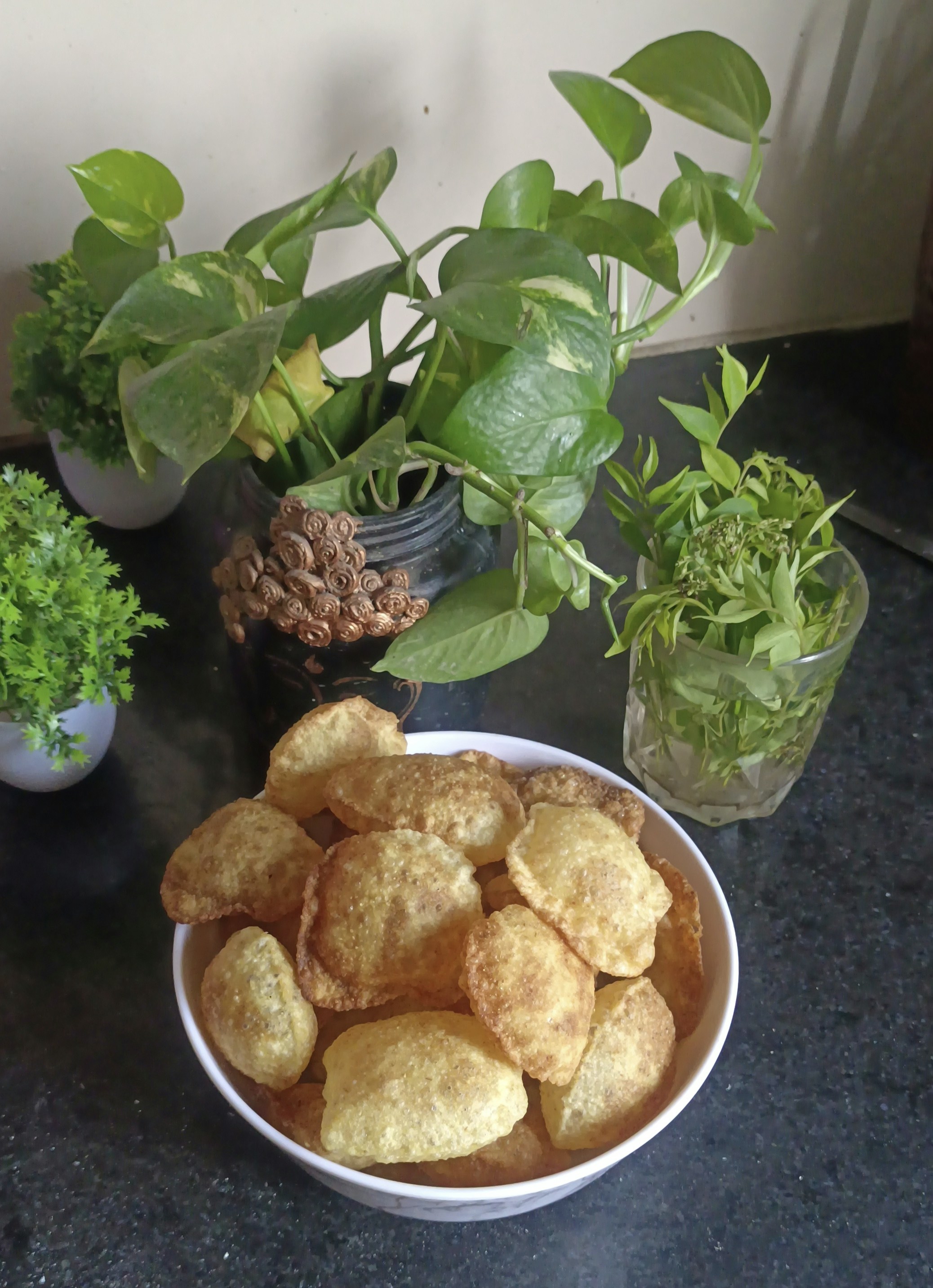 Puffy golden puris with yellow potato bhaji on a dark plate, rustic setting