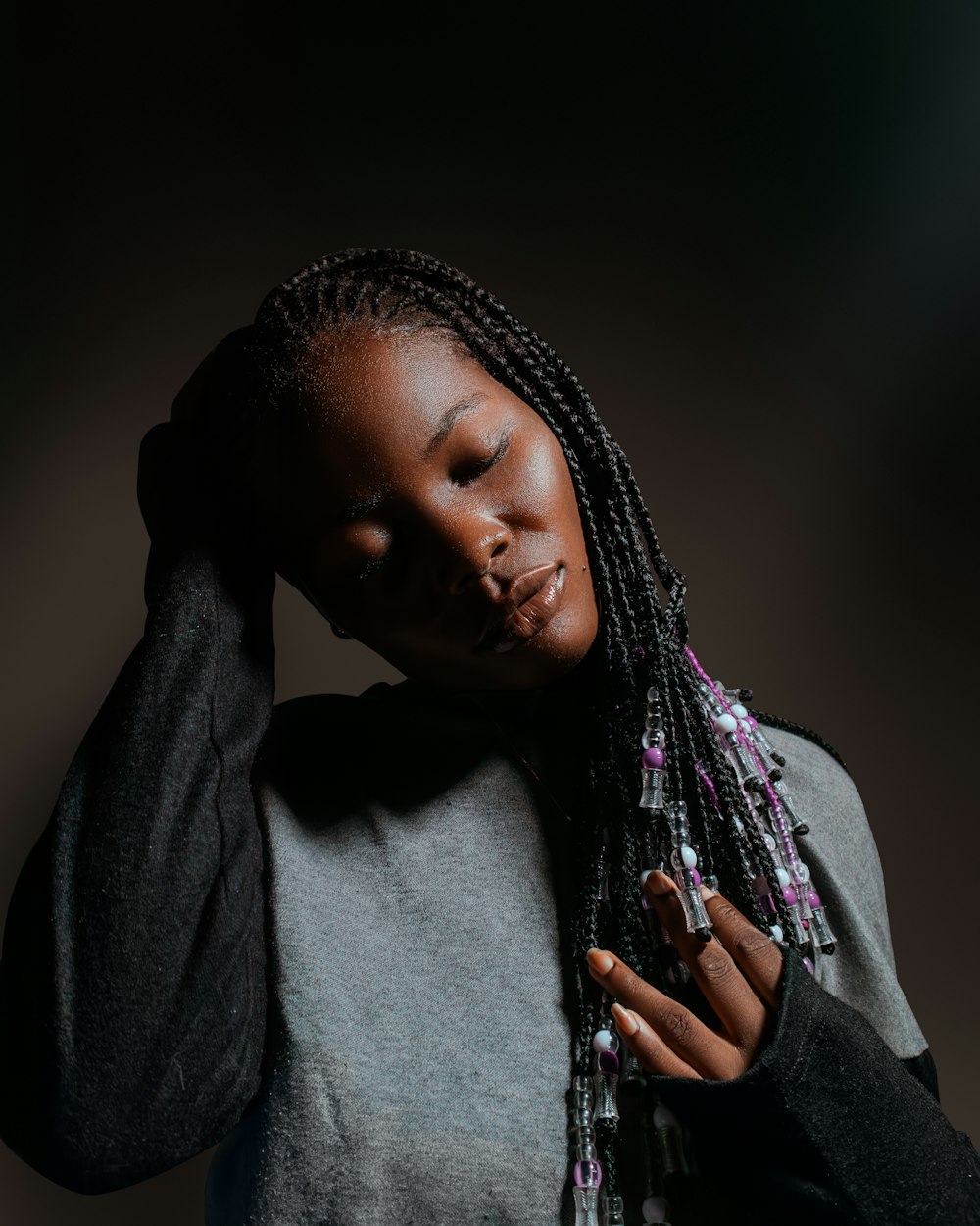 a woman with dreadlocks holding her head in her hands