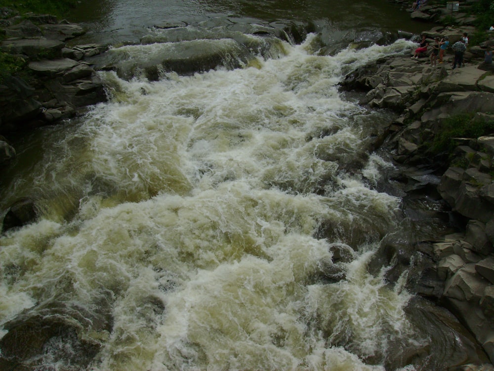 a man standing on a rock next to a river