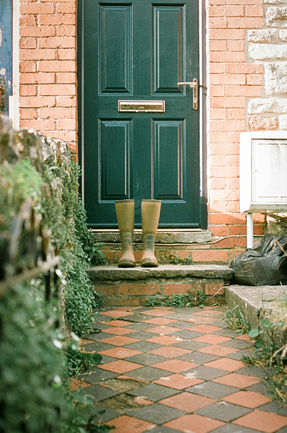 a green door and a brick building