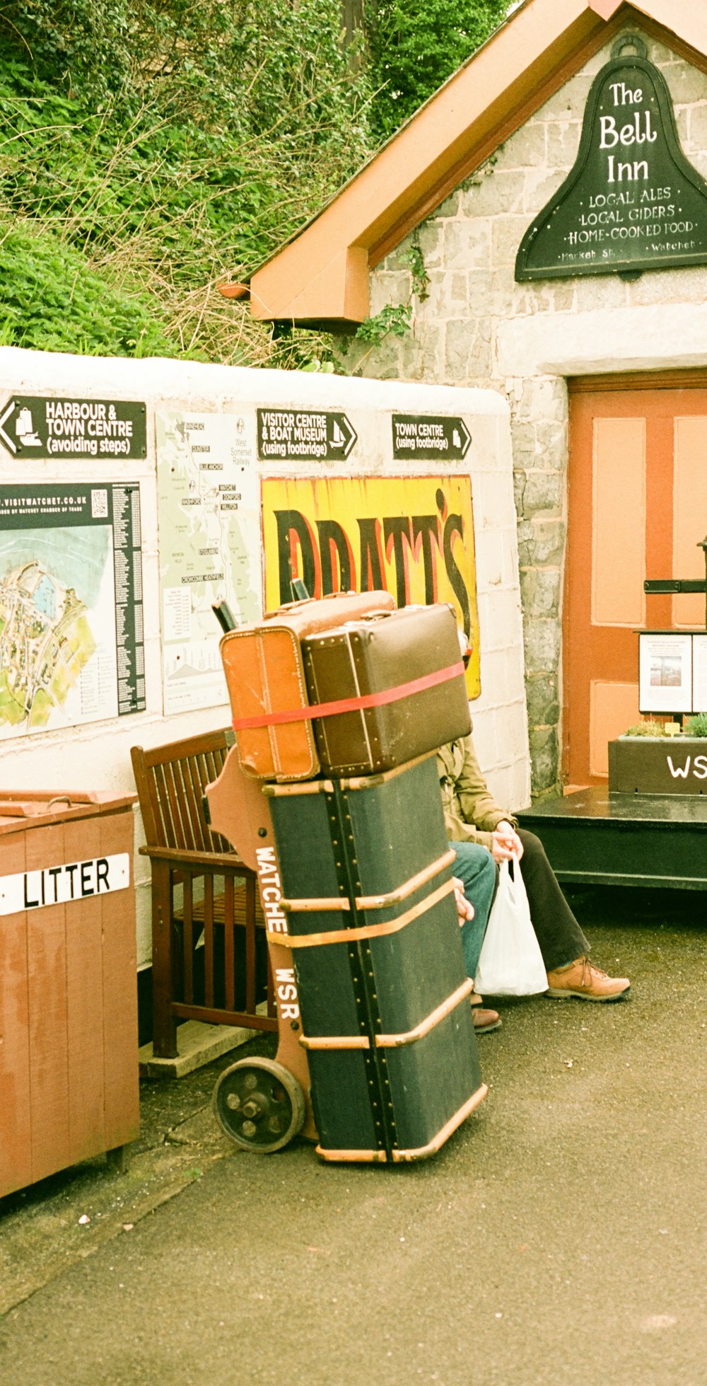 a man sitting on a chair next to a pile of luggage