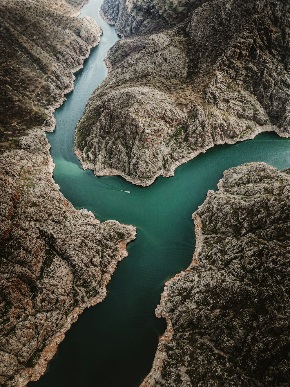 an aerial view of a river surrounded by mountains