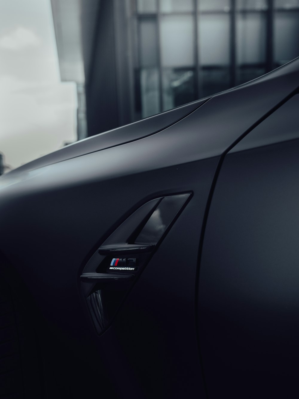 a close up of a car door handle with a building in the background