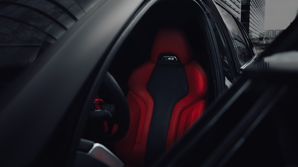 the interior of a car with red and black seats