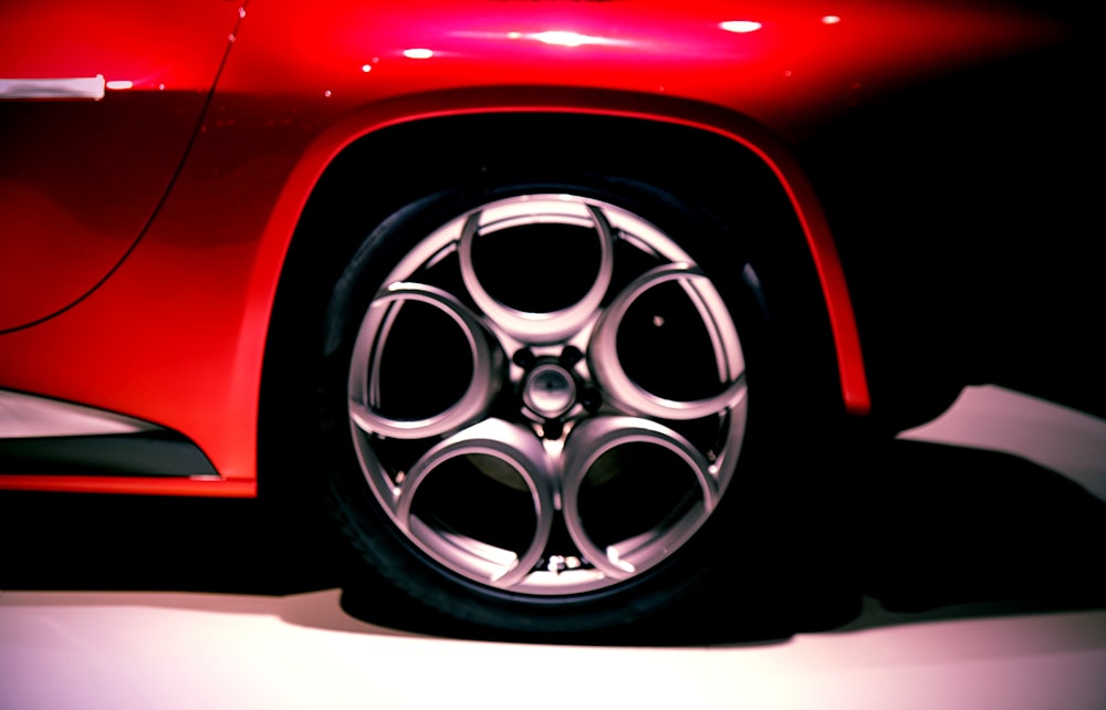 a close up of a red sports car wheel