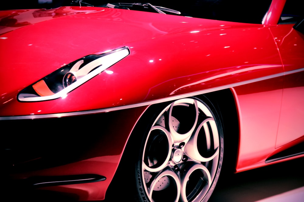 a close up of a red sports car on display