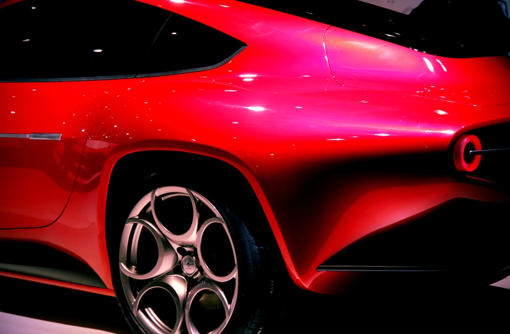 a close up of a red sports car on display