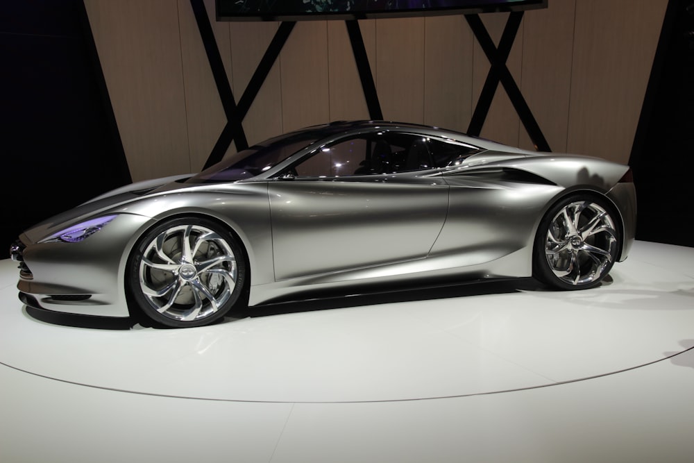 a silver sports car on display at a show