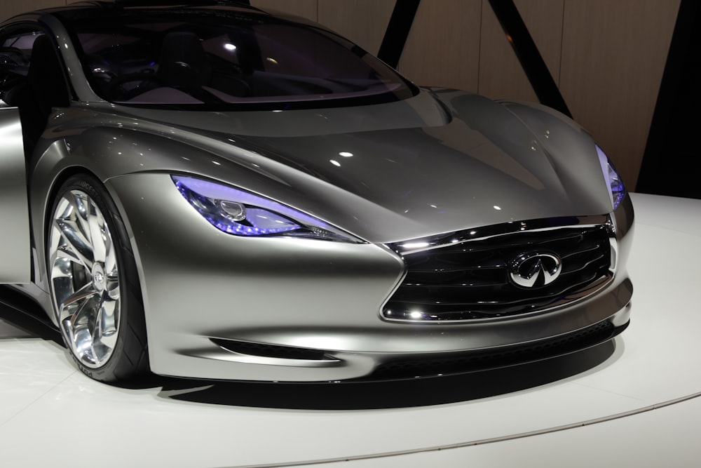 a silver sports car on display at a car show