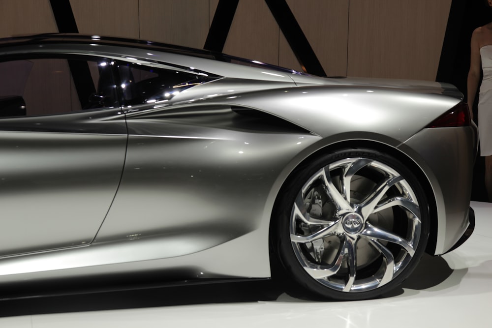 a silver sports car on display at a car show