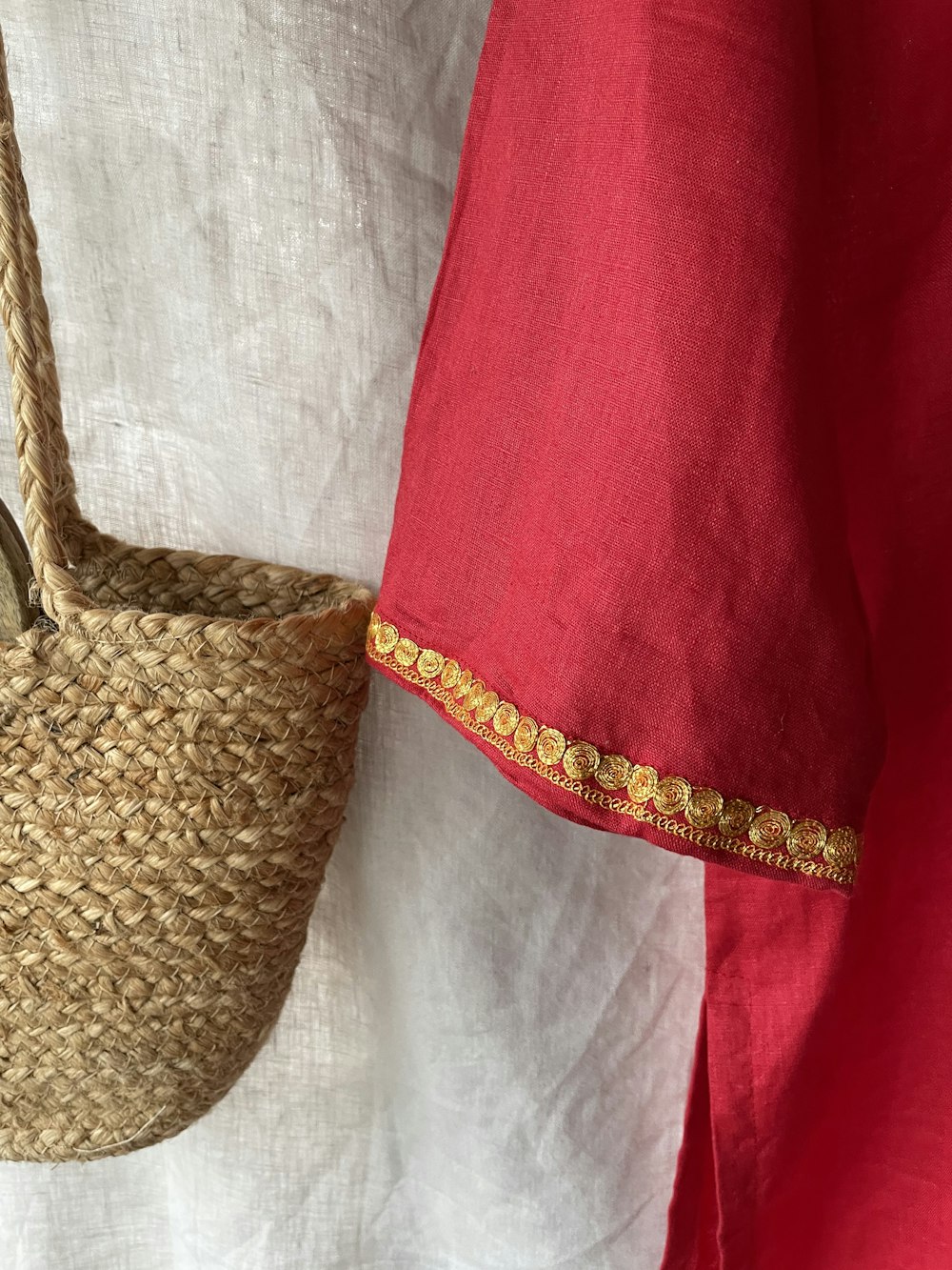a straw basket hanging on a red and white wall