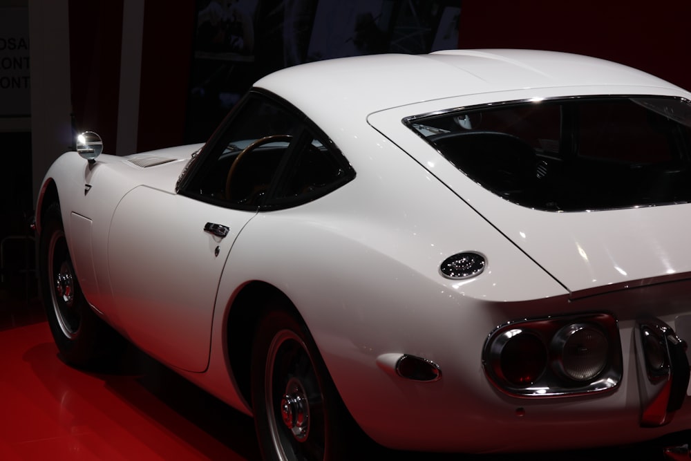 a white sports car on display at a car show