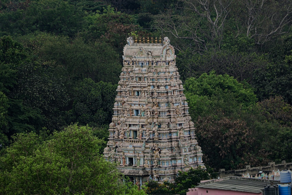 a very tall tower sitting in the middle of a forest