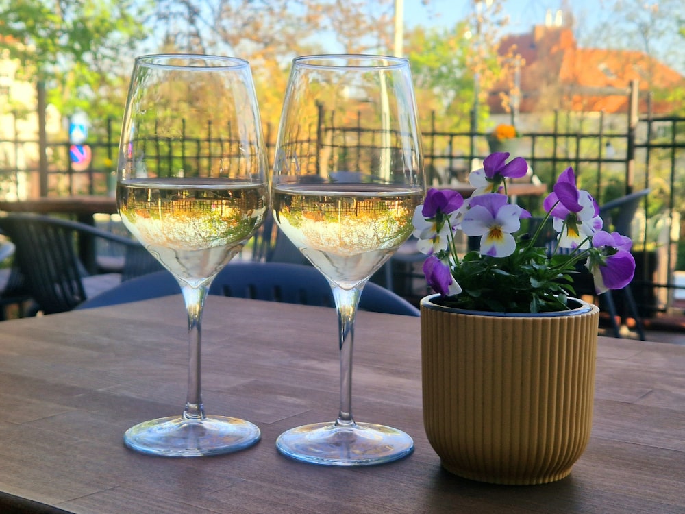 a couple of wine glasses sitting on top of a wooden table