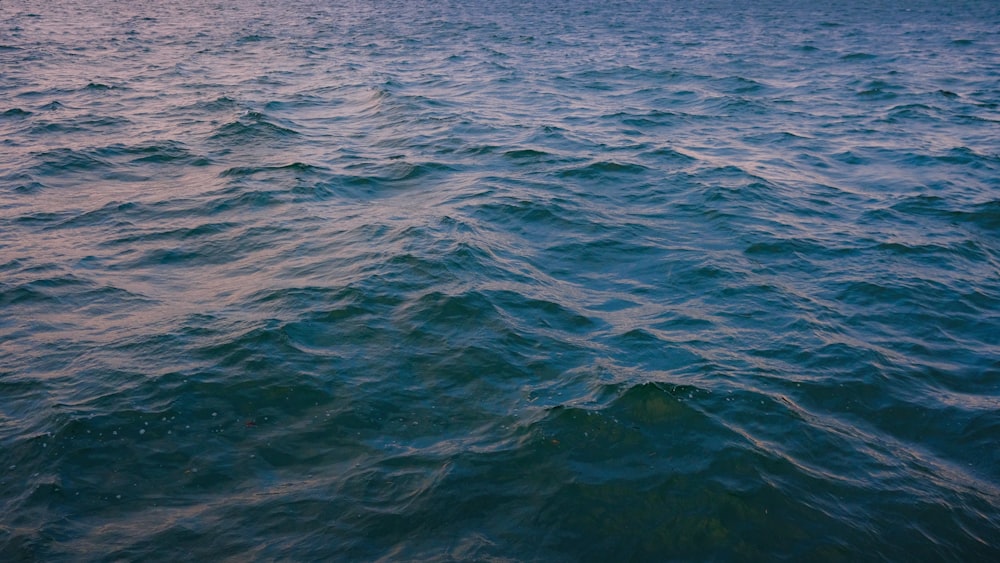 a large body of water with a boat in the distance