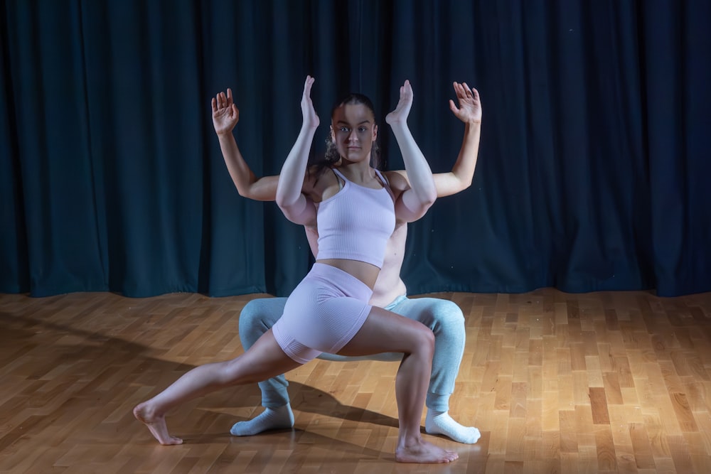 a man and a woman doing yoga on a wooden floor