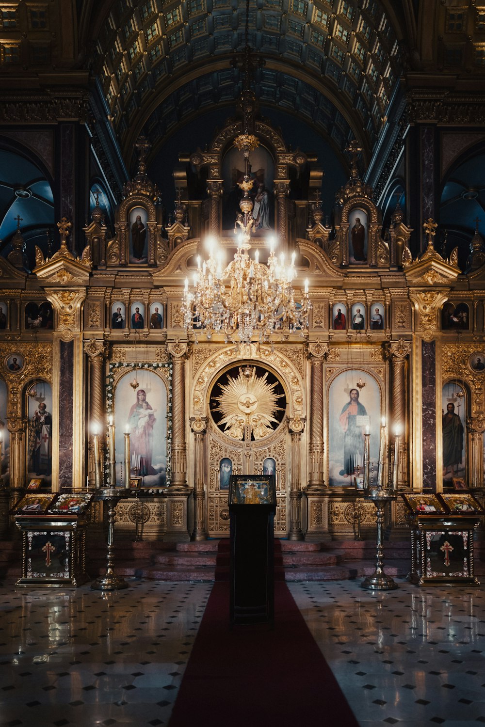 a church with a chandelier and paintings on the wall