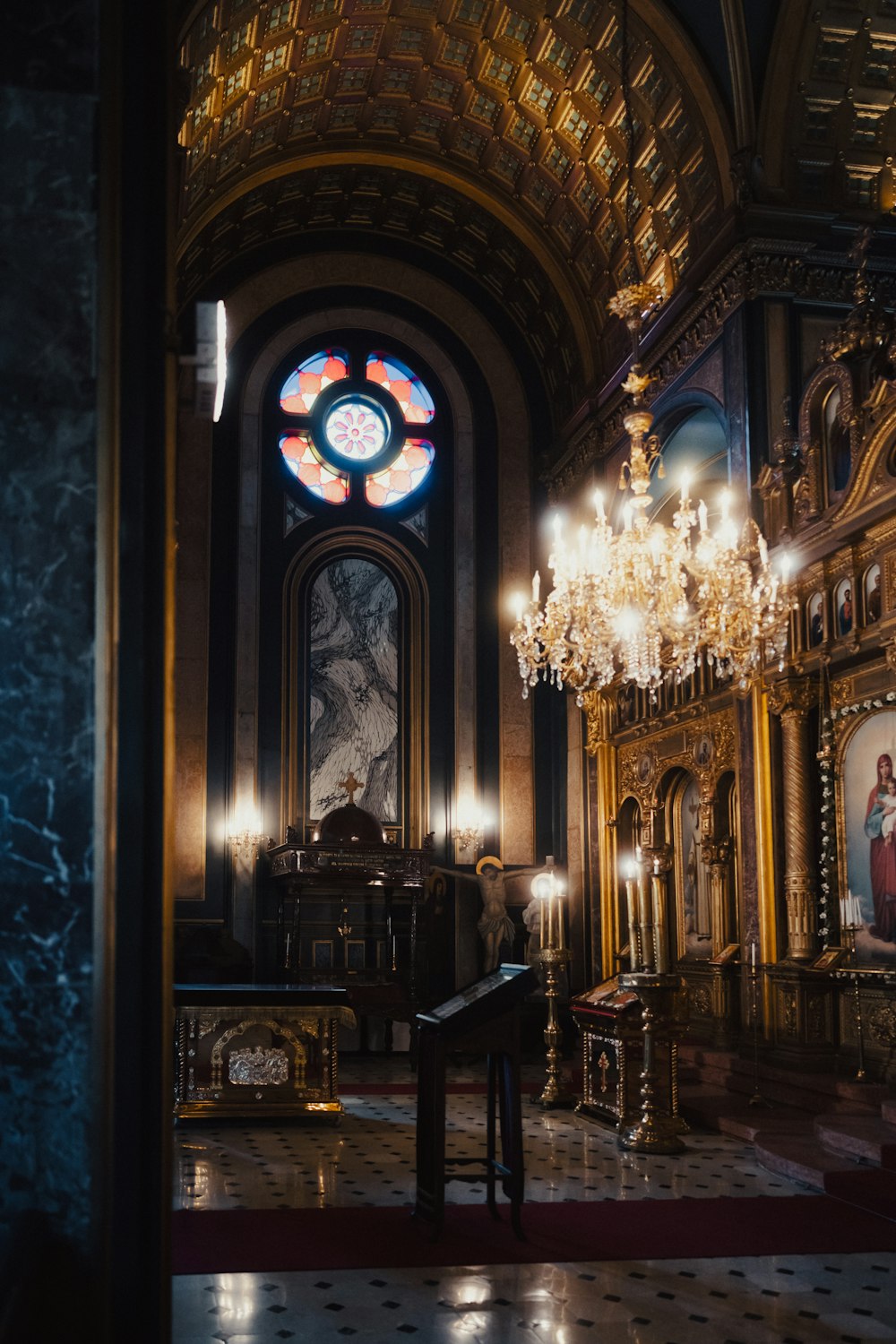 a church with a chandelier and a stained glass window