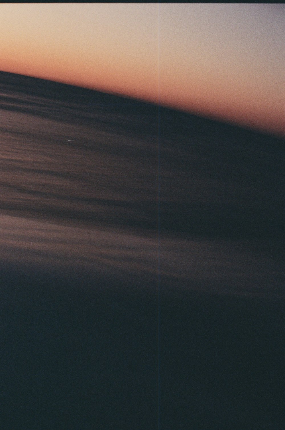 una foto sfocata dell'oceano al tramonto