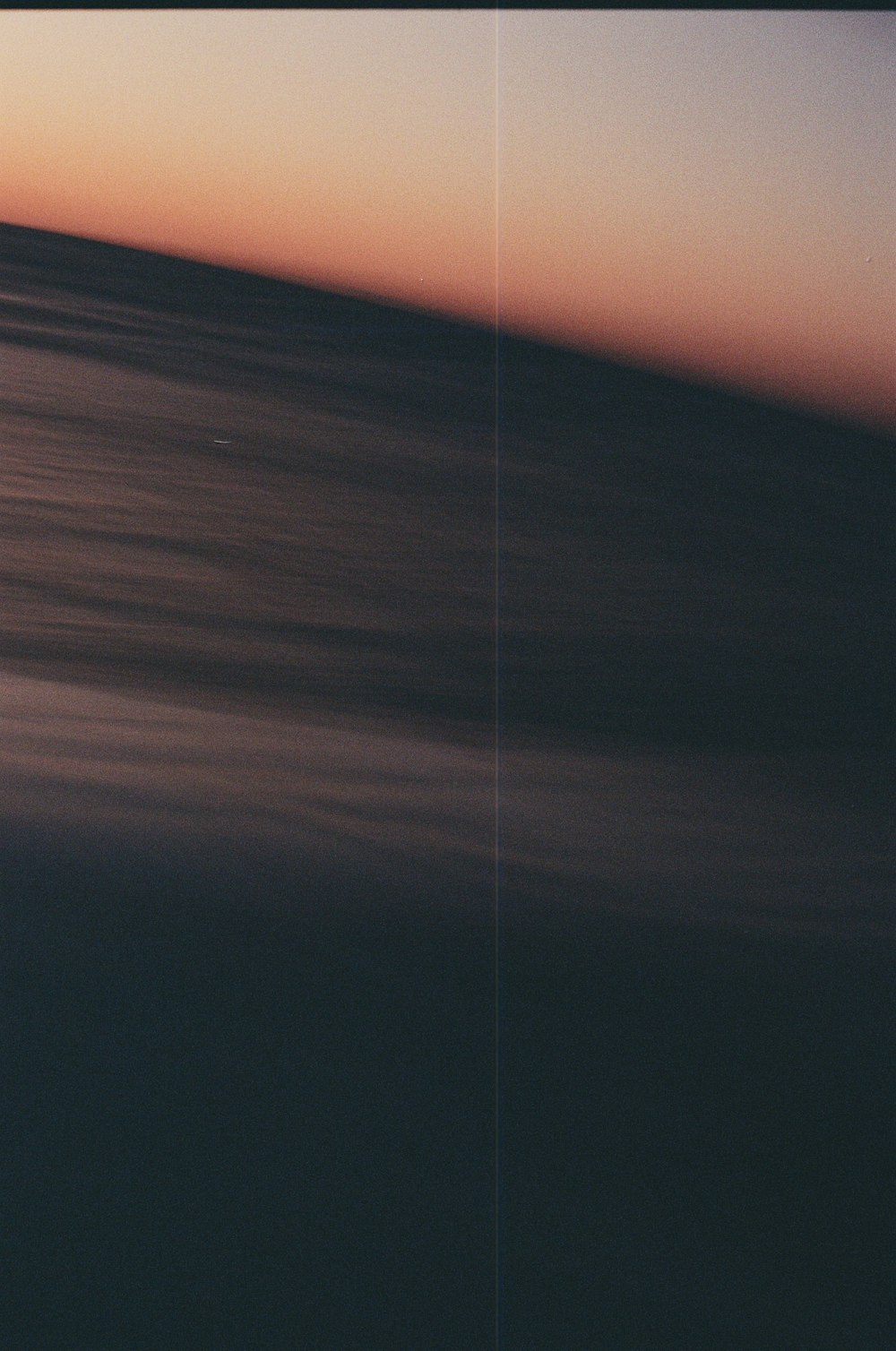 a blurry photo of the ocean at sunset