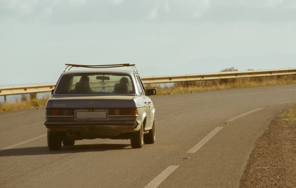 a car driving down a road next to a bridge