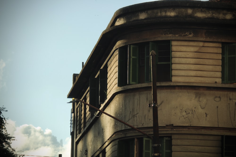 a run down building with green shutters on the windows