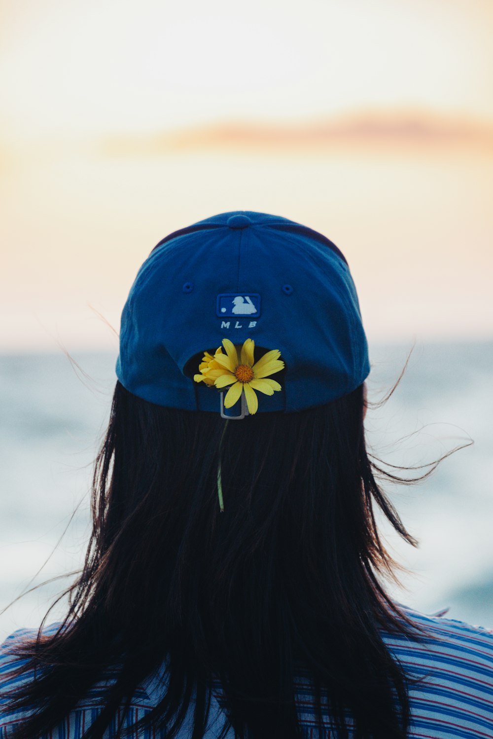 the back of a person wearing a hat with a flower on it