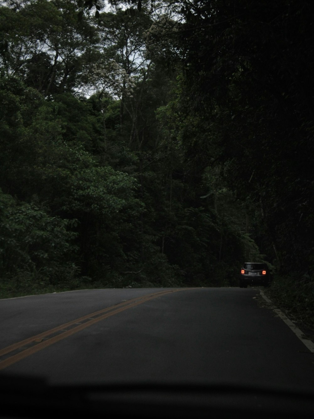 a car driving down the road in the dark