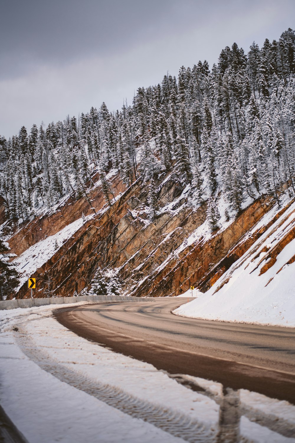 a snow covered mountain with a road going through it