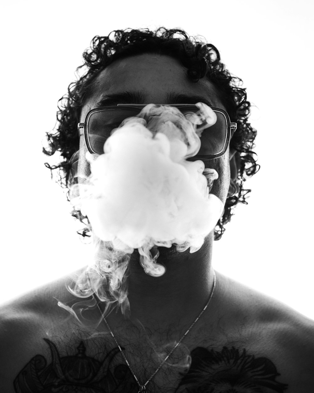 a man smoking a cloud of white smoke