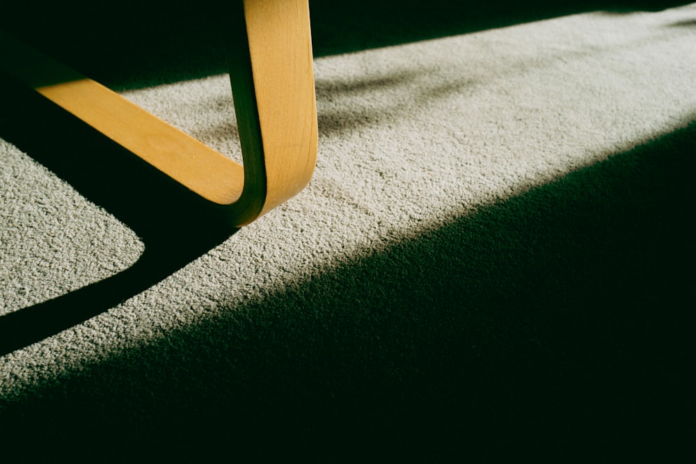 a close up of a wooden bench on a carpet