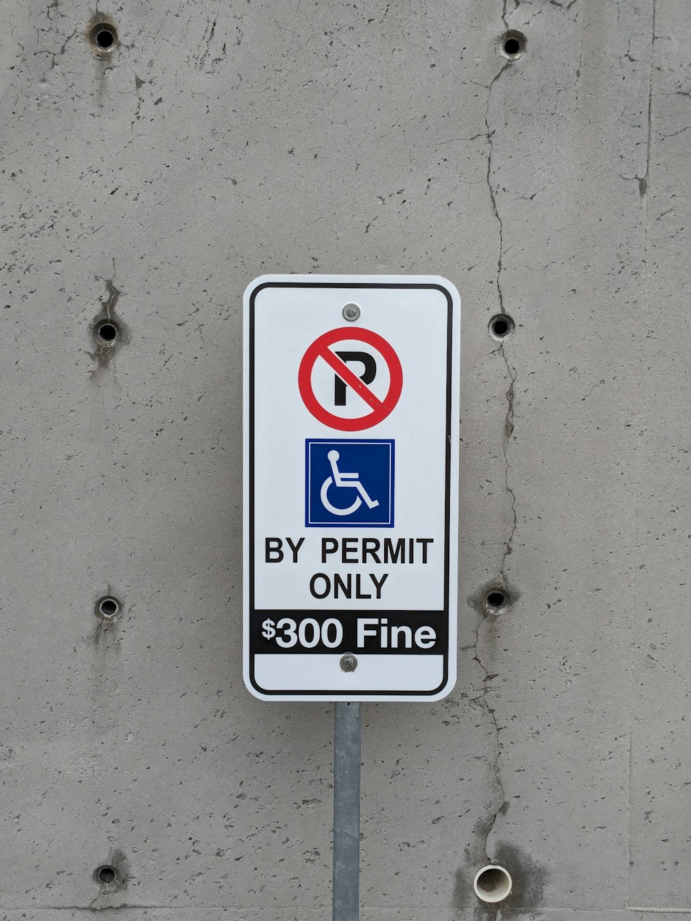 a no parking sign on a concrete wall