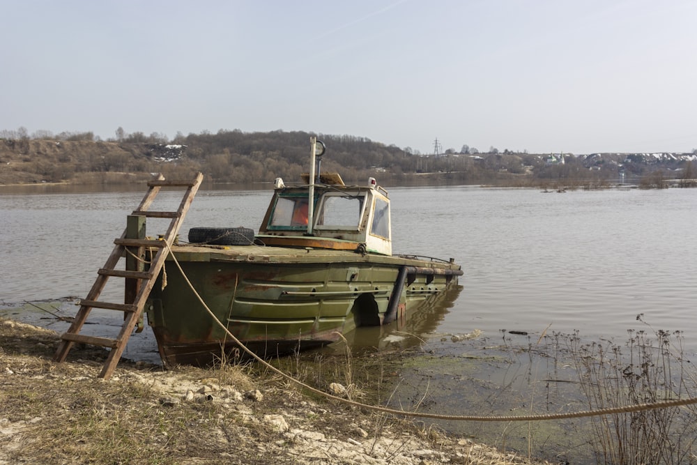 a green boat sitting on top of a body of water