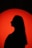 a silhouette of a woman in front of a red circle
