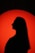 a silhouette of a woman in front of a red circle