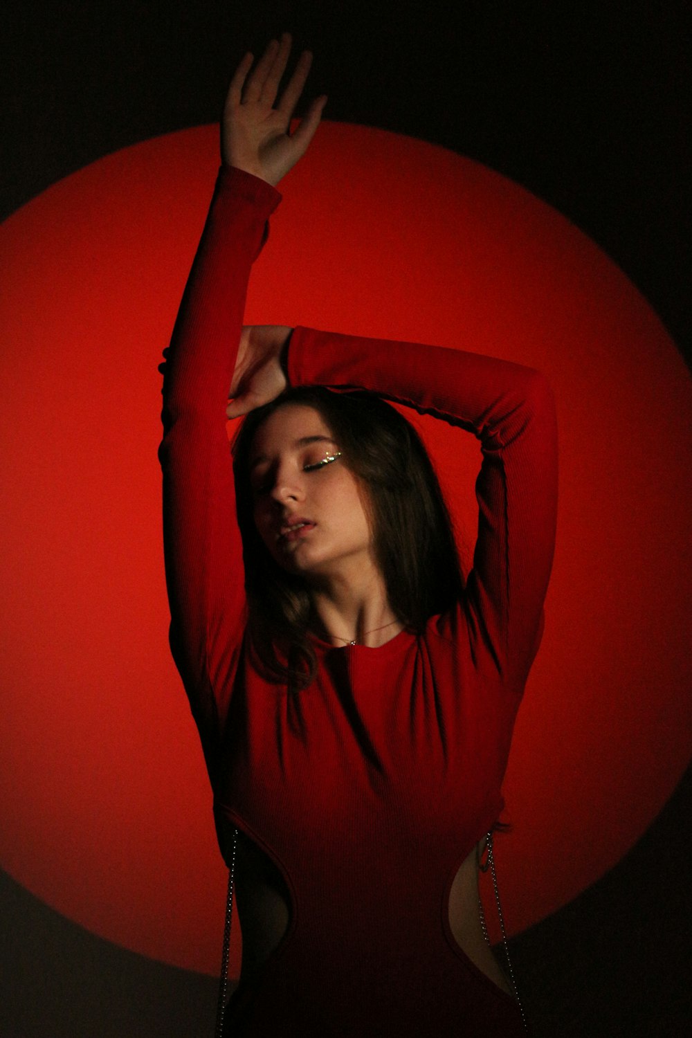 a woman in a red shirt is holding her arms up